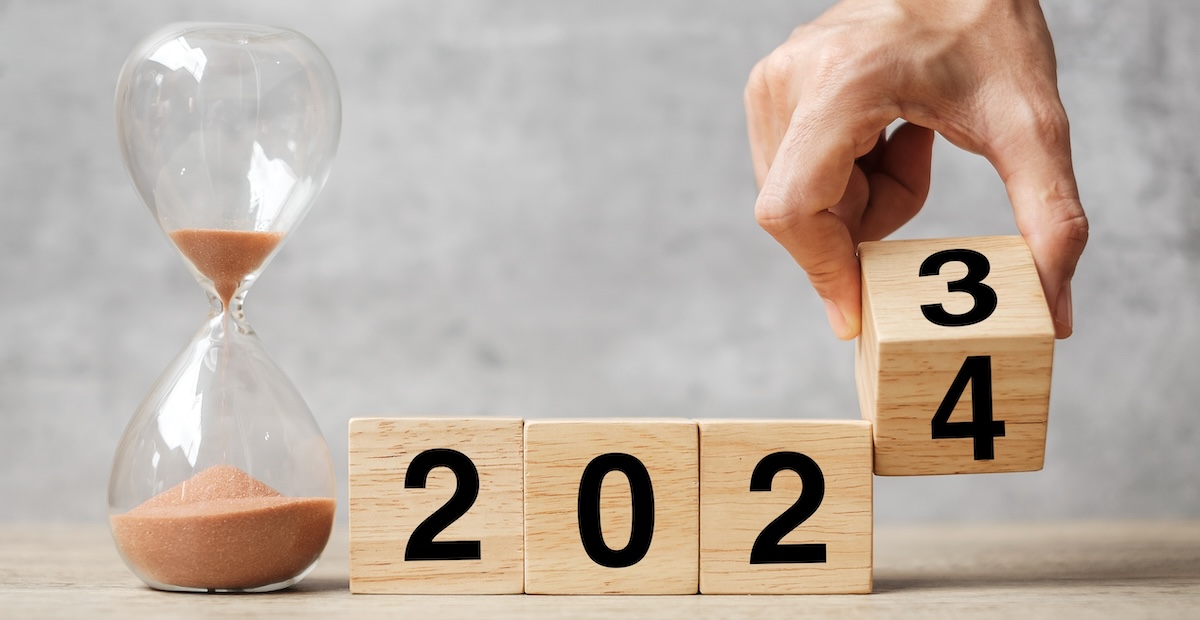 Hand Flipping Number Block 2023 To 2024 With Hourglass On Table