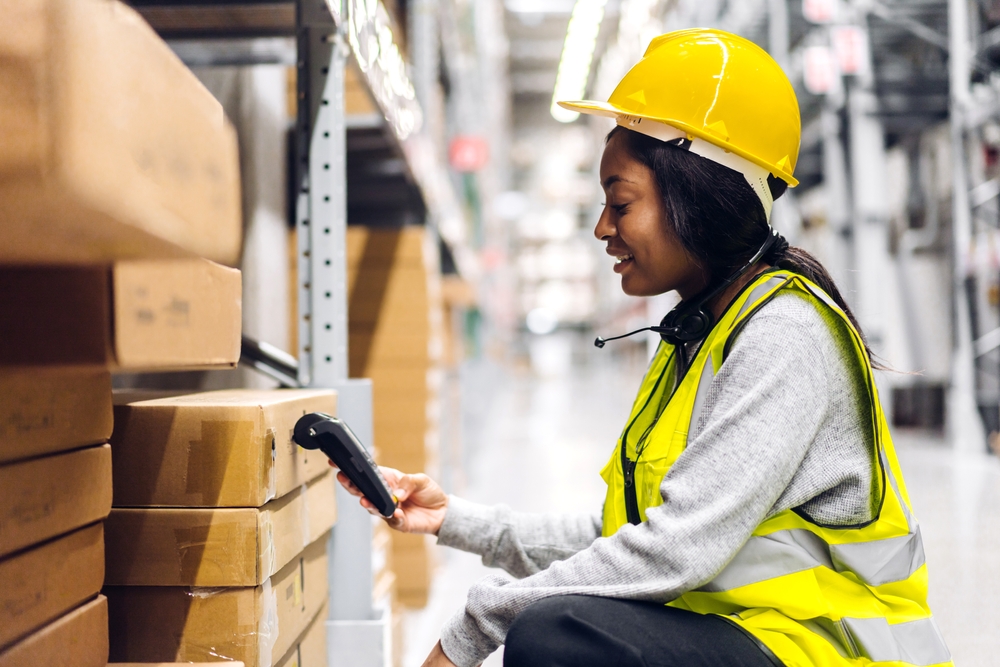 african american female warehouse worker using rf barcode scanner