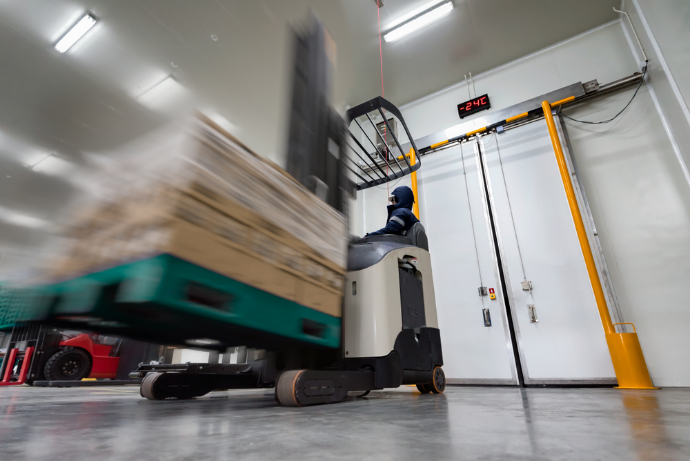 forklift moving pallet in cold storage warehouse