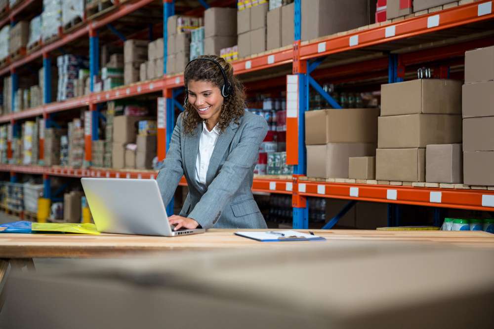 female distribution manager using oms automation software in warehouse
