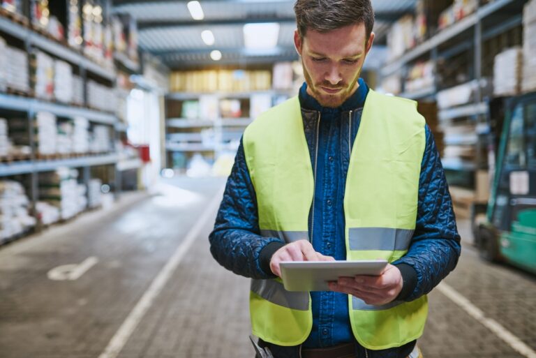male warehouse worker using distribution order management system