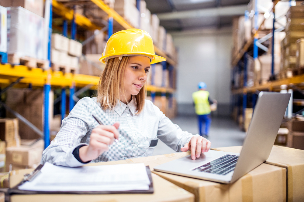 female warehouse manager using wms software in warehouse