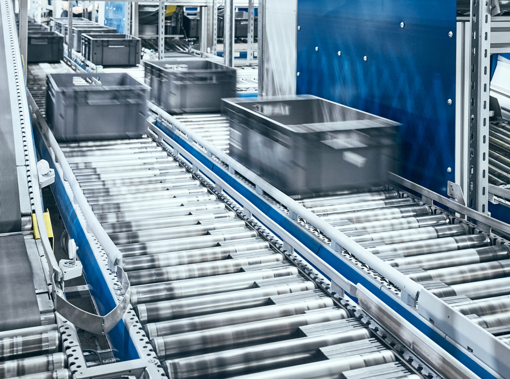 bins on conveyor of automated storage and retrieval system used for warehouse order picking 