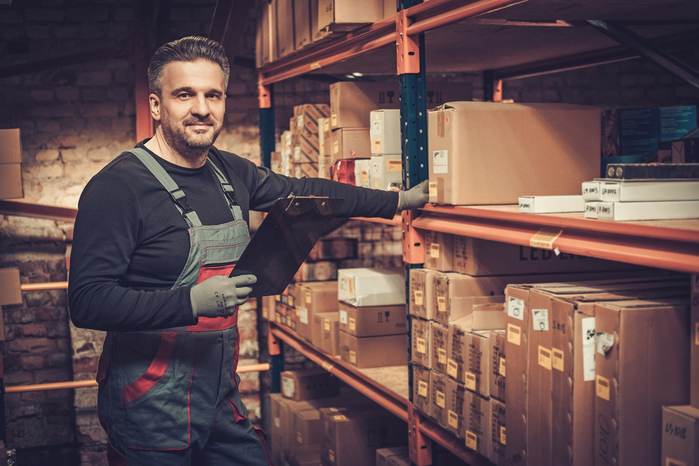 man with clipboard picking orders in warehouse