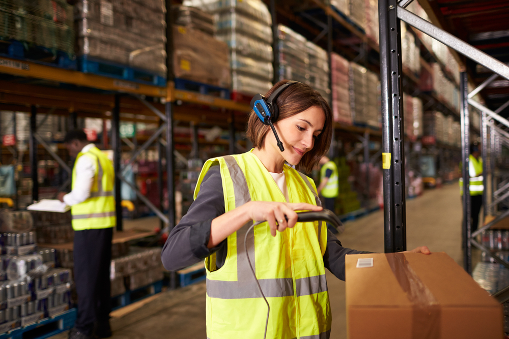woman wearing voice picking headset scanning an item in warehouse