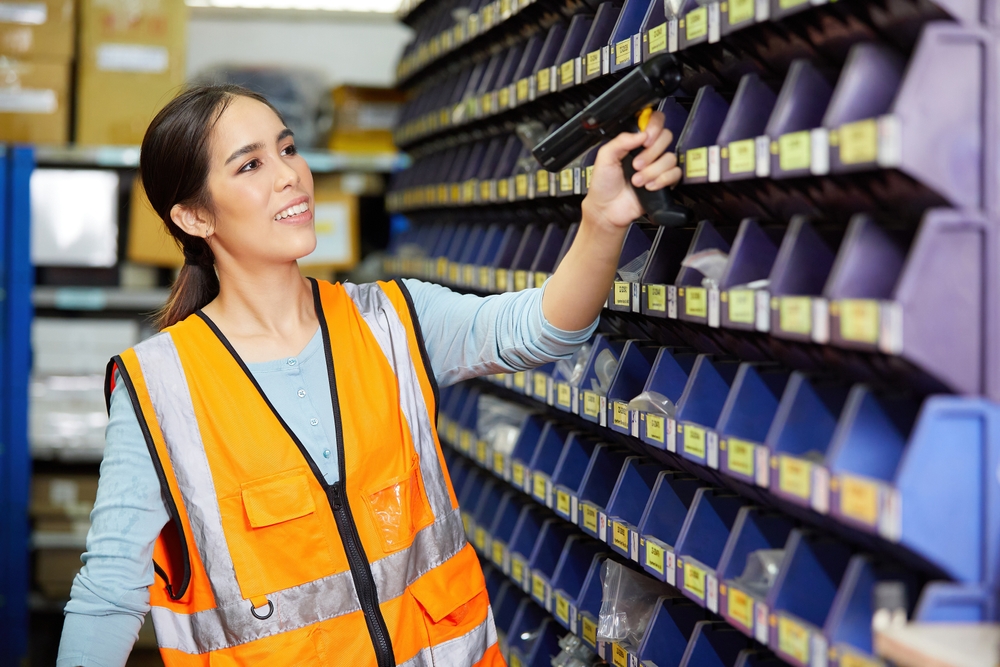 female warehouse staff using handheld rf barcode scanner order picking technology