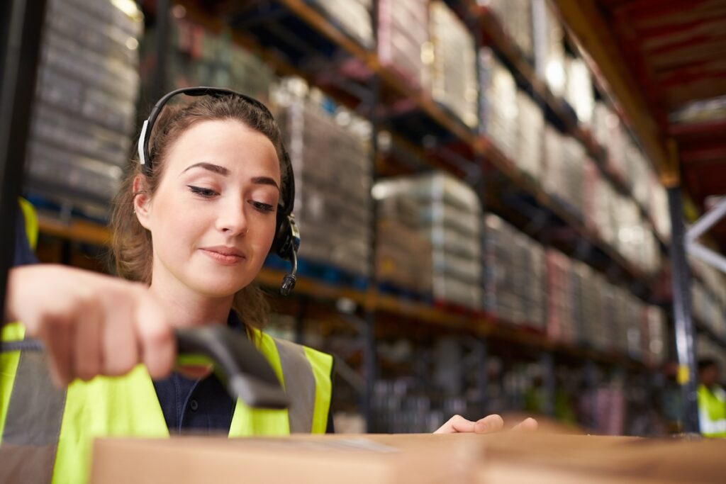 female warehouse staff using barcode scanner order picking technology