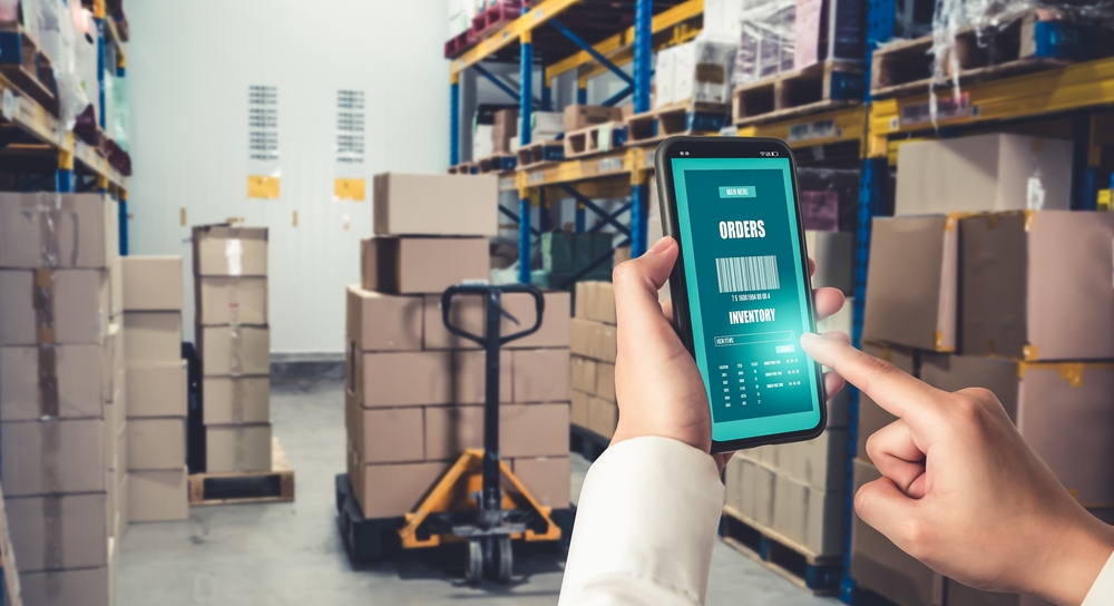 hands holding a mobile ERP solution in a distribution warehouse