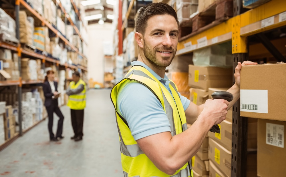 smiling male warehouse worker using industry tailored erp