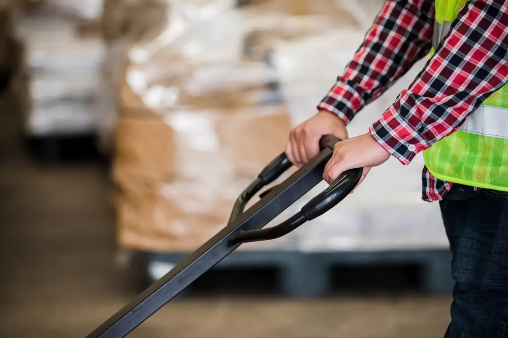 warehouse worker pulling pallet of received inventory