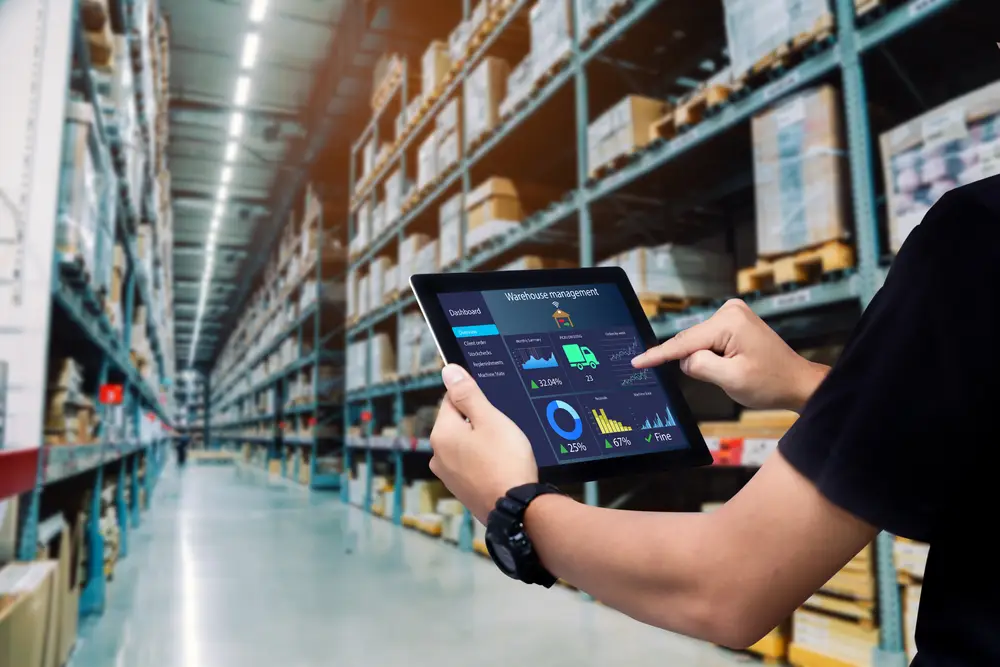 man holds warehouse management system wms tablet in warehouse