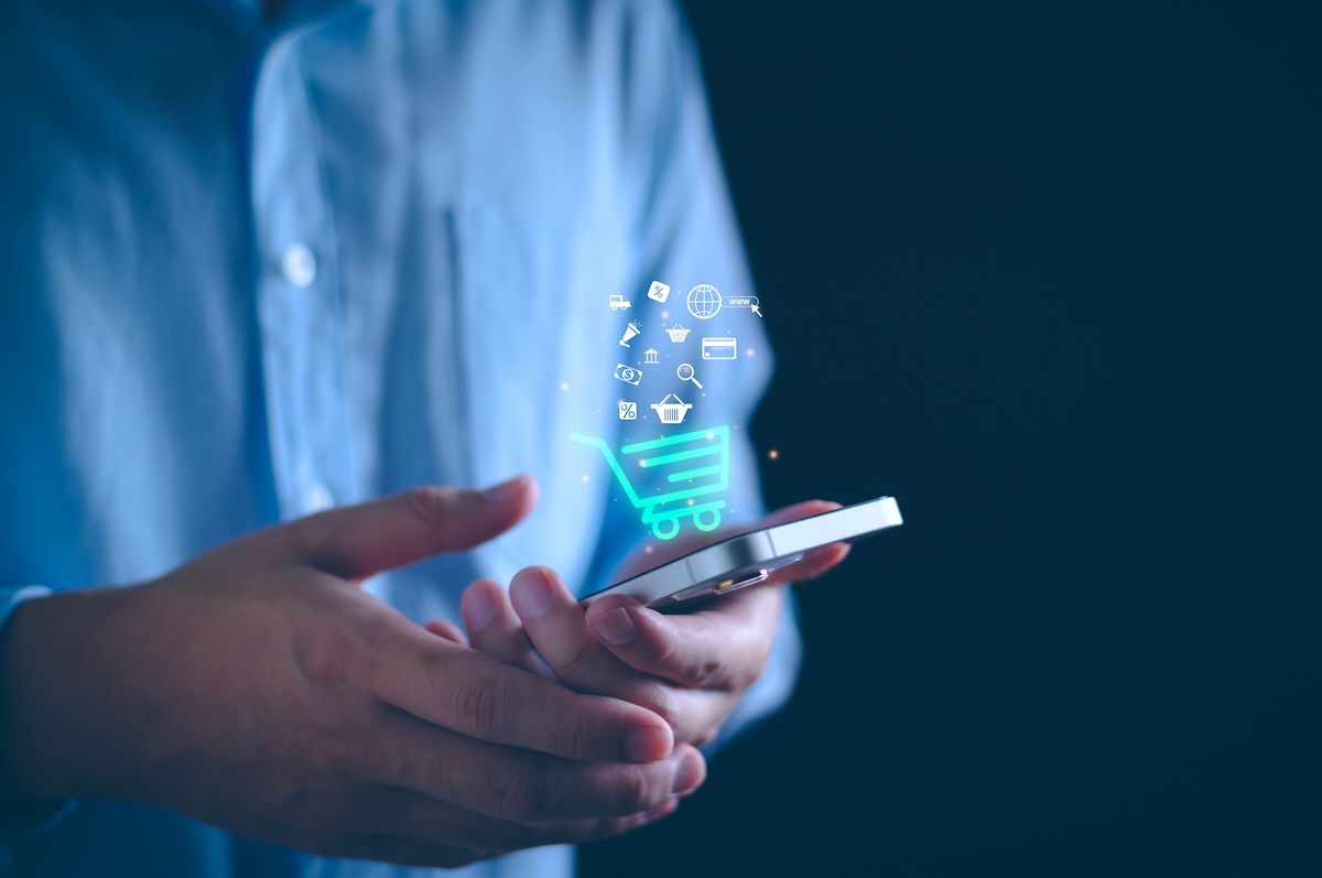 man holding smartphone with e-commerce illustration