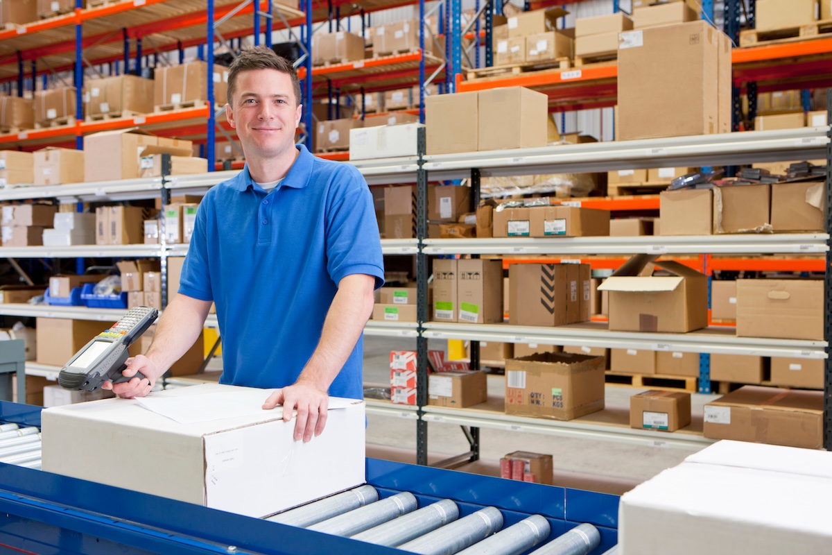 distribution warehouse worker near inventory and a conveyor